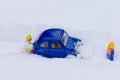 Man pushing car stuck in snow. Toy models. Royalty Free Stock Photo